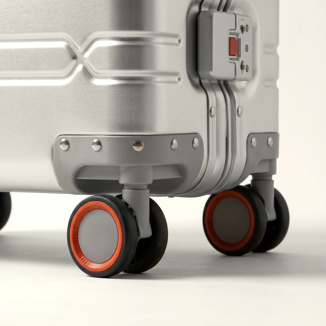 Dubbele 360 graden spinnerwielen met oranje accent van de DS ONE aluminium koffer, close-up