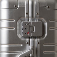 Close-up van het TSA cijferslot op de geborstelde aluminium zijkant van de DS ONE koffer