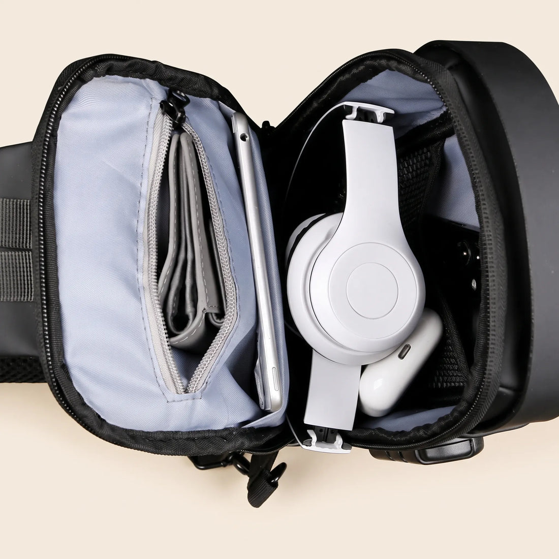 Geopende DS Lock crossbody tas met tablet, portemonnee, koptelefoon en telefoon, bovenaanzicht