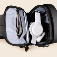 Geopende DS Lock crossbody tas met tablet, portemonnee, koptelefoon en telefoon, bovenaanzicht