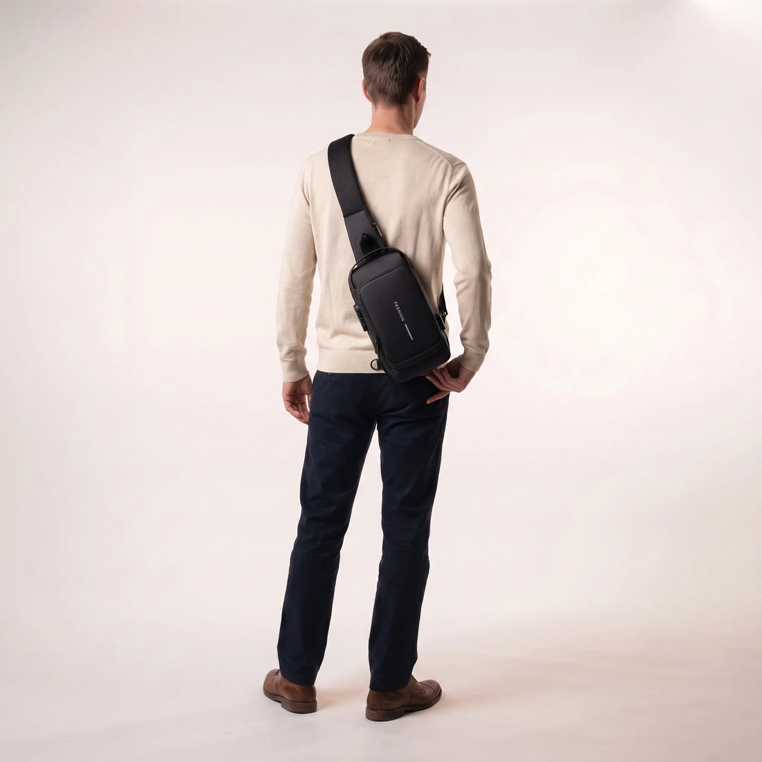 Man draagt de zwarte DS Lock crossbody tas schuin op de rug, toont het compacte formaat
