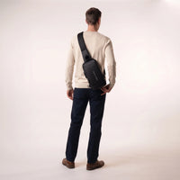 Man draagt de zwarte DS Lock crossbody tas schuin op de rug, toont het compacte formaat