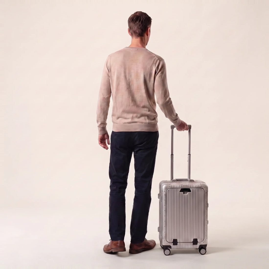 Man met de zilveren DS Front handbagage koffer aan de trolleystang, toont het cabineformaat
