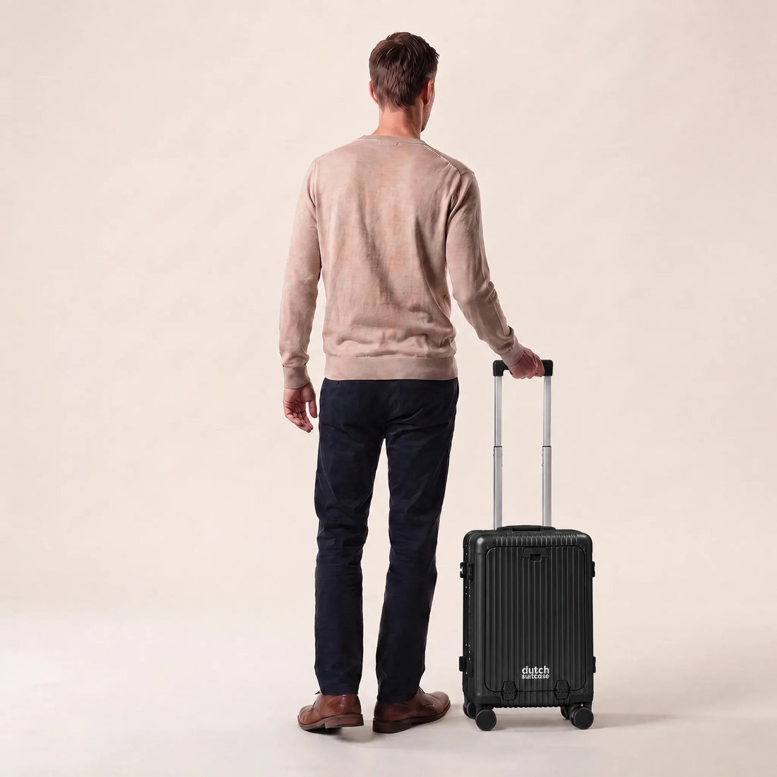Man met de zwarte DS Front handbagage koffer aan de trolleystang, laat het handbagageformaat zien