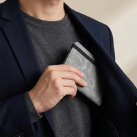 Man steekt de grijze DS Wallet reisportemonnee in de binnenzak, compact reisformaat
