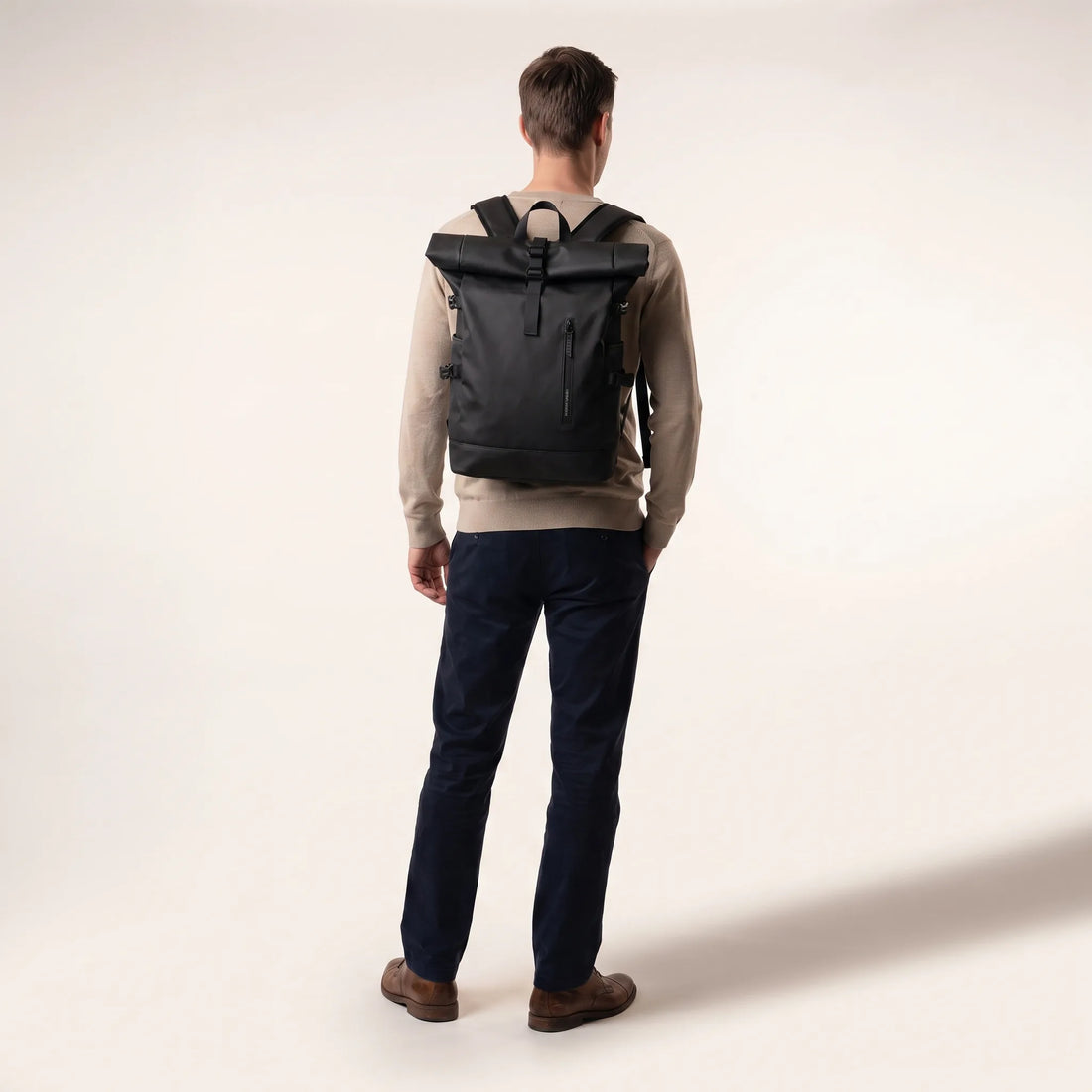 Man draagt de zwarte DS Elevate rolltop rugzak op de rug, toont het formaat van de 27 liter rugzak