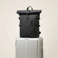 Zwarte DS Elevate rugzak staat op een aluminium handbagage koffer, ideale reiscombinatie