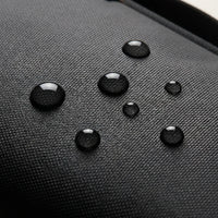 Waterdruppels parelen af op het waterafstotende nylon van de DS Tech organizer, macro