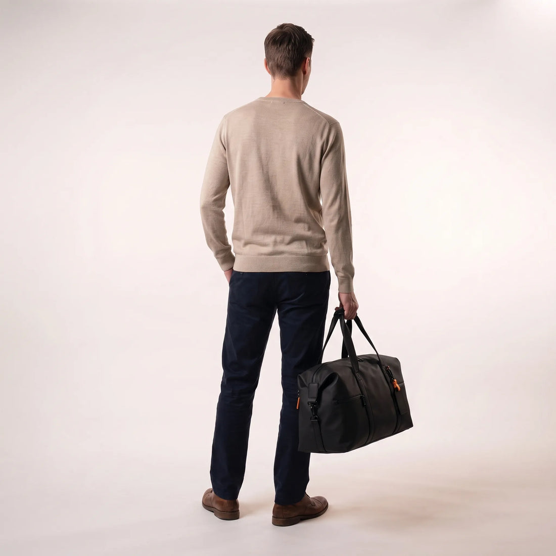 Man draagt de zwarte DS Volt weekendtas in de hand, toont het 21 liter handbagage formaat